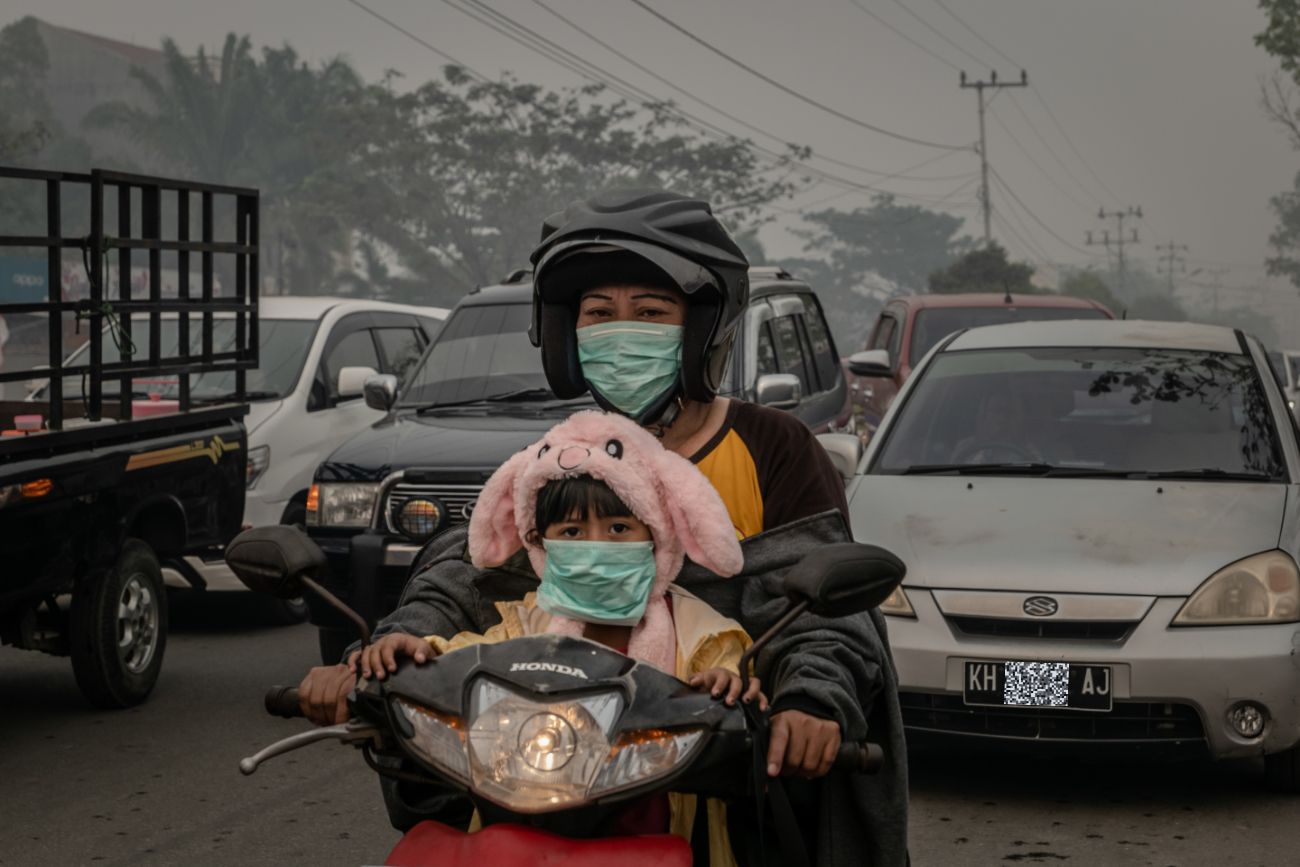 Pemotor menggunakan masker di jalanan berasap akibat karhutla di Kota Palangkaraya, Kalimantan Tengah ©Ulet  Ifansasti/Greenpeace